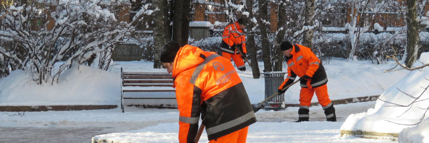 Arbeiter räumt Schnee mit Schaufel auf Gehweg.