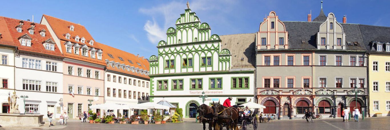 Historischer Marktplatz mit Fachwerkhäusern und Kutsche.