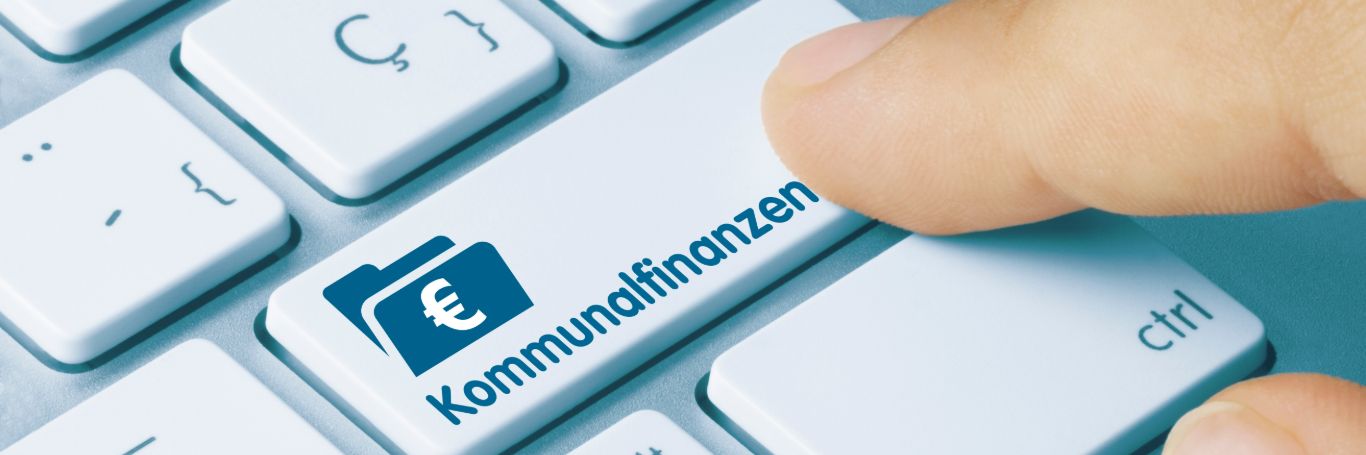 Tastatur mit Taste „Kommunalfinanzen“ und Finger.