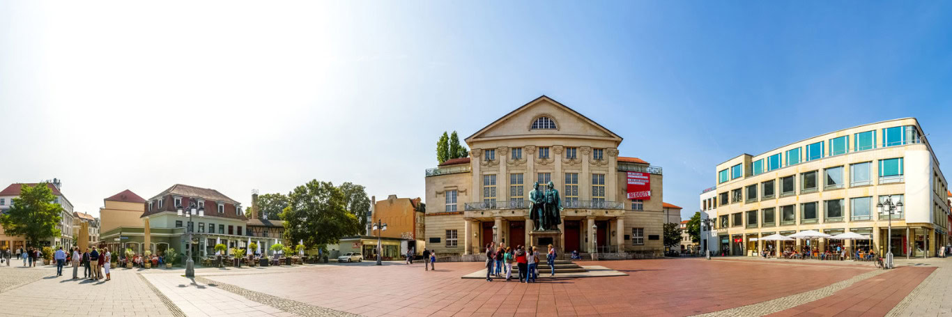 Theaterplatz mit Goethe-Schiller-Denkmal und Besuchern.